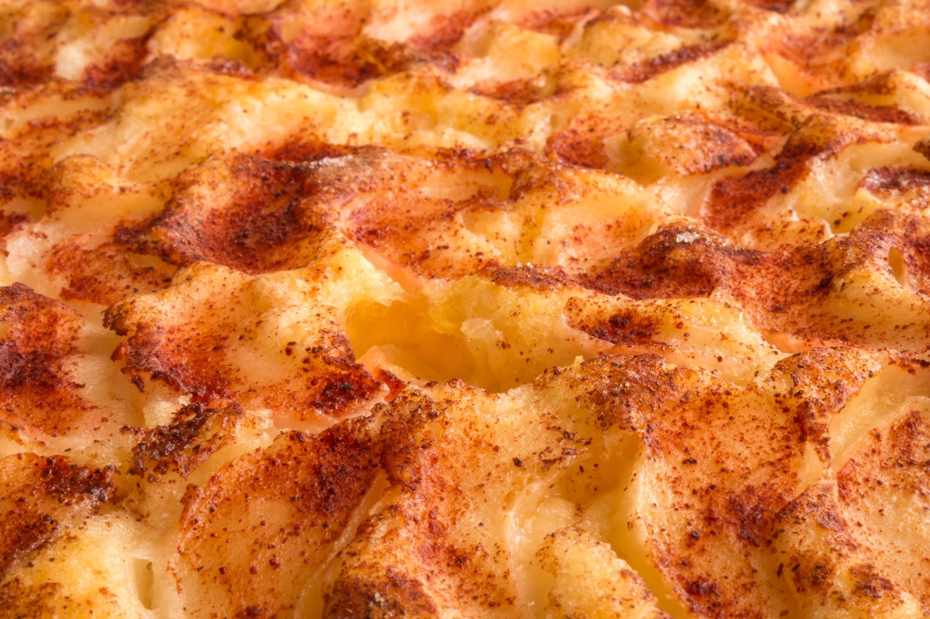 Extreme close-up of a bubbling, golden-scorched five-cheese crust