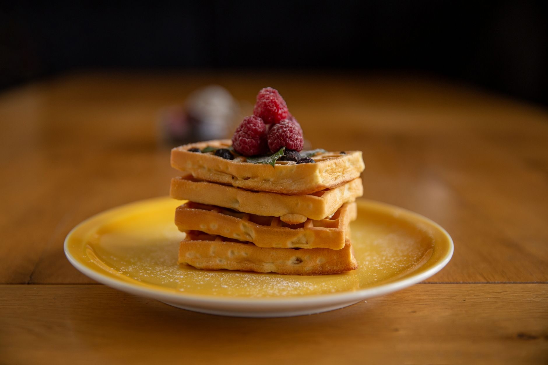 A waffle stack against a deep amber background